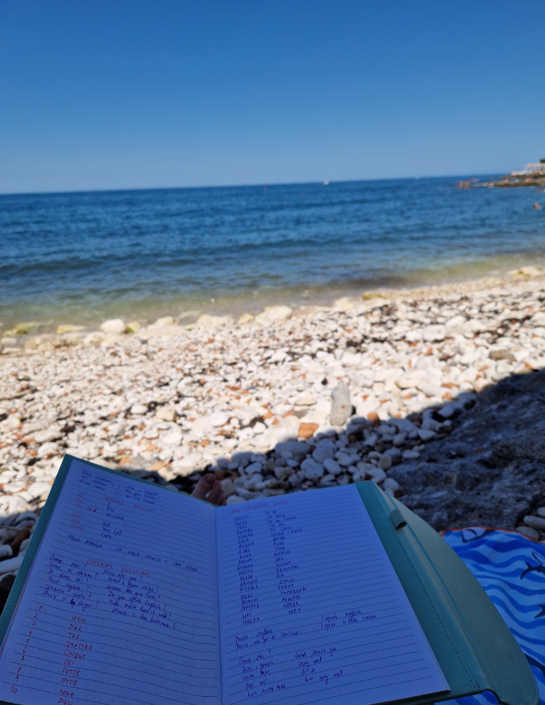 Notebook with Italian vocabulary on a pebble beach in southern Italy